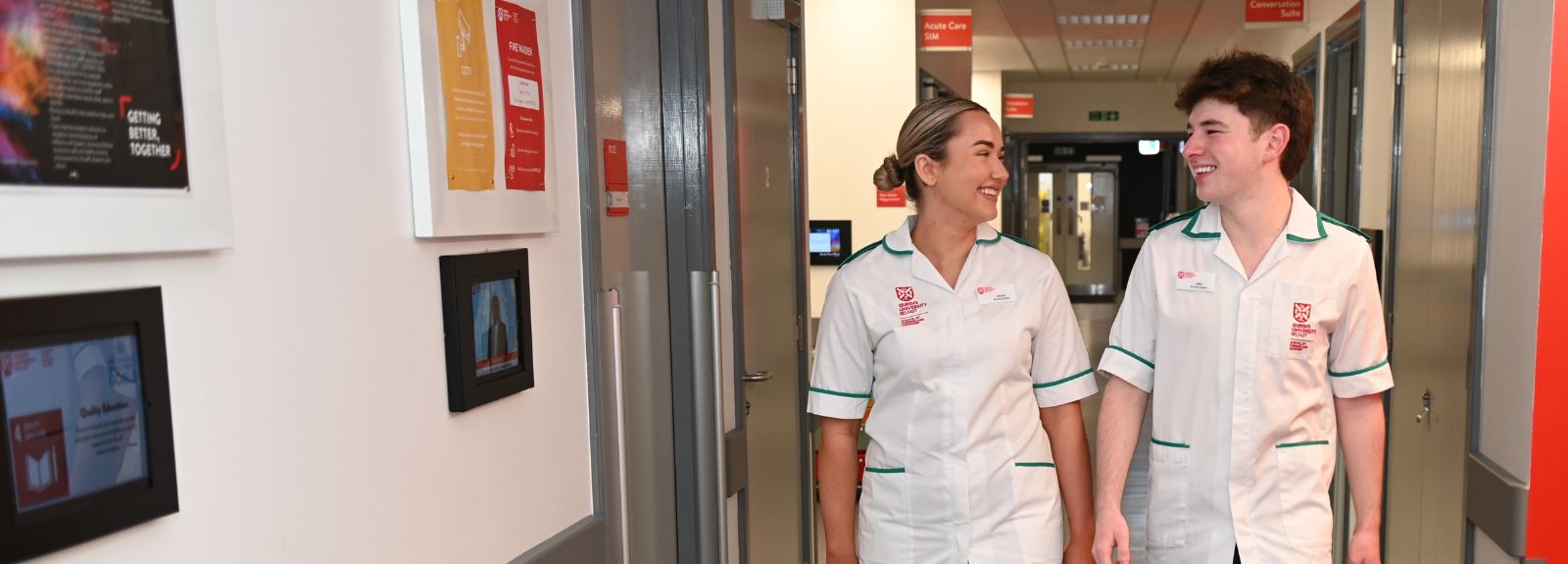 Two nurses smiling and walking down a corridor