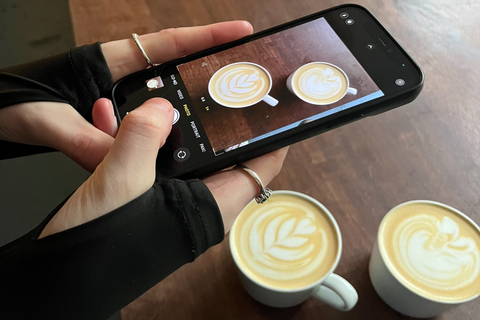 Student taking picture of two coffee cups
