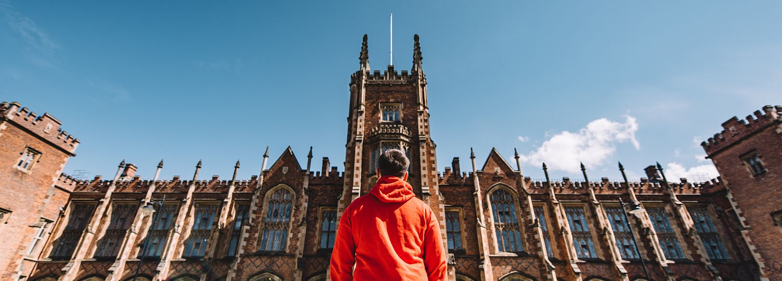 Student in red hoodie looking at the lanyon