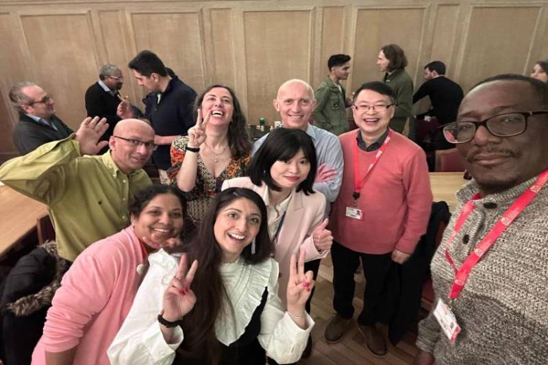 A very diverse group of adults posing and smiling