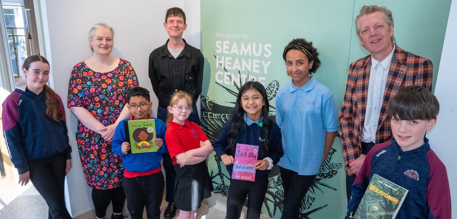 school children and adults holding books at a celebratory event at the Seamus Heaney Centre