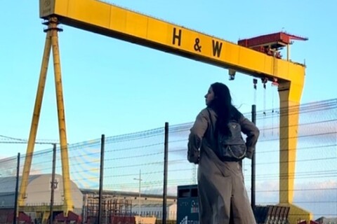 Student walking in front of Harland and Wolff cranes