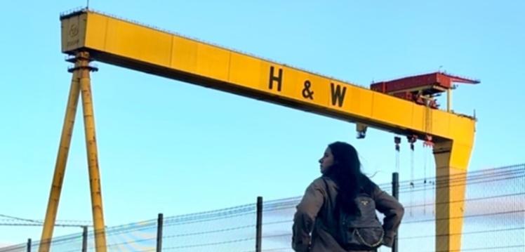 Student standing in front of H&W cranes