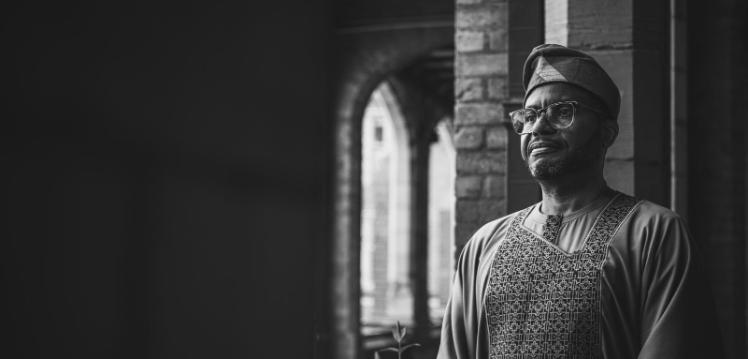 black and white picture of a man standing in the cloisters