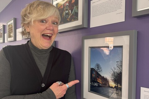 Student Lesley in front of her photo for the AEL photography competition