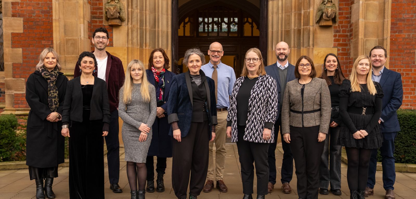 A group of people standing at the steps of the Lanyon Building at Queen's