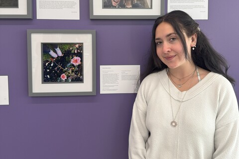 Student Mackenzie stands in front of her photo submission for the AEL photography competition