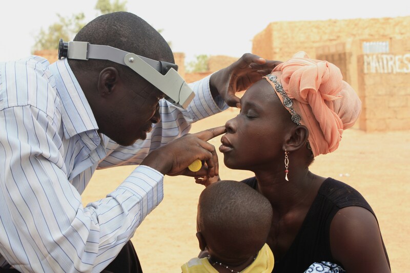 Man examining woman's eye