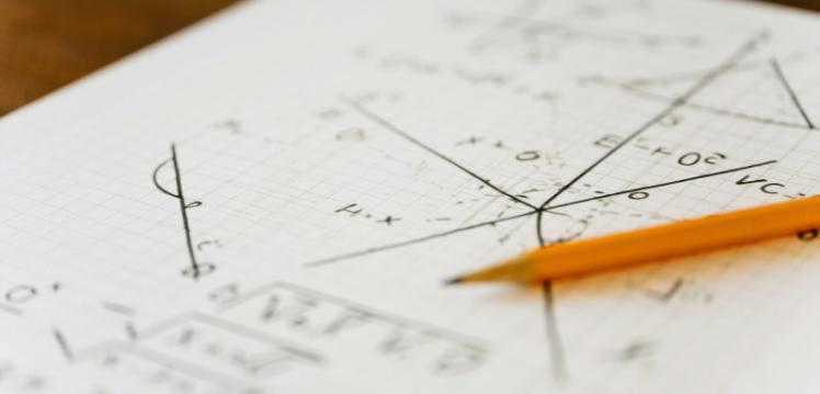 Maths equation on paper with pencil on top
