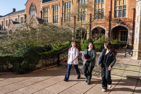 Three mature students walking through the quad