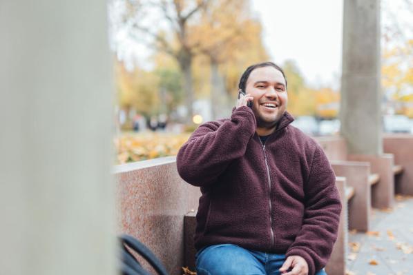 Student Miguel on his phone outside the McClay