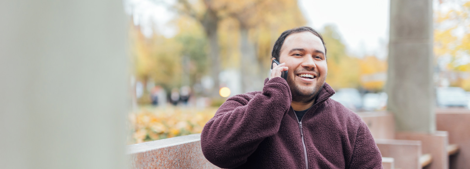 Student Miguel taking a phone call outside the McClay