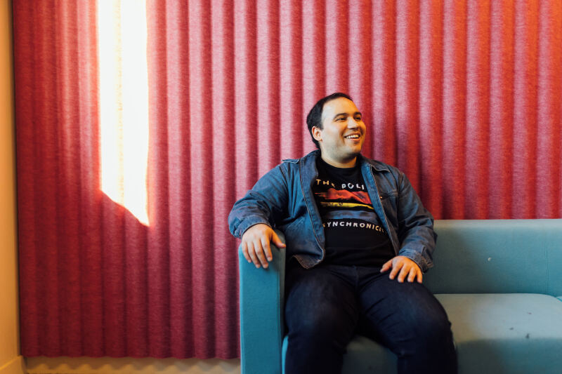 Student Miguel sits on sofa in One Elmwood