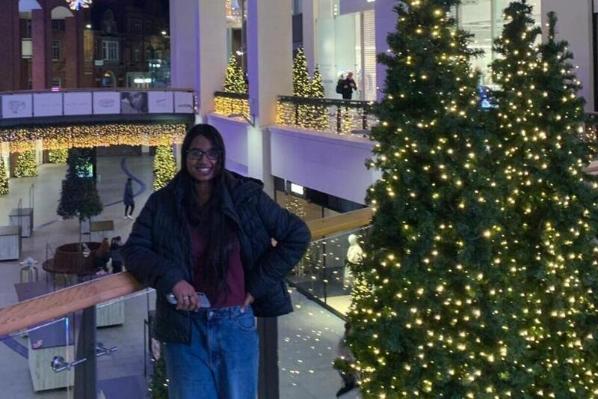 Natasha beside Christmas trees in Victoria Square