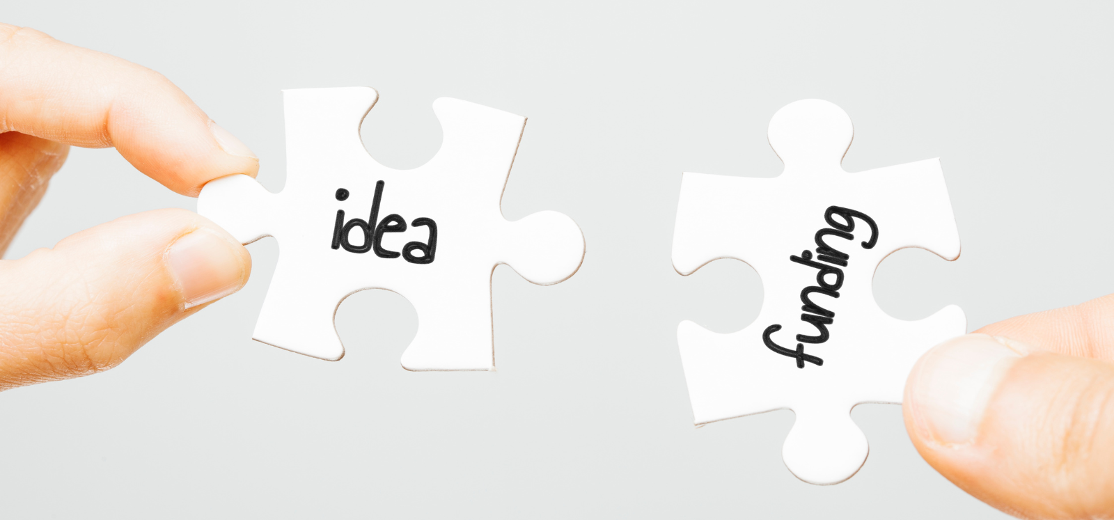 Two hands each holding a puzzle piece, joining them together. One puzzle piece is labelled “Innovative Ideas” and the other is labelled “Funding.” The image symbolises the powerful connection between creative innovation and financial support coming together to build successful solutions.