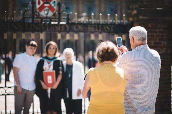 Parents taking photo of child at graduation