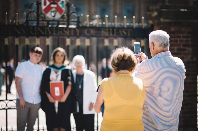 Parents taking photo of child at graduation