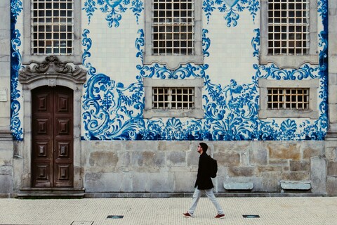Person walking past house in Porto