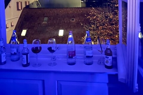 Glasses on bottles sitting on a window sill