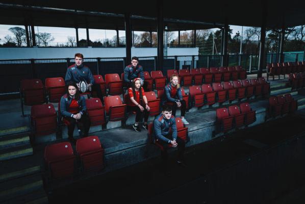 QUB sports students sitting on benches
