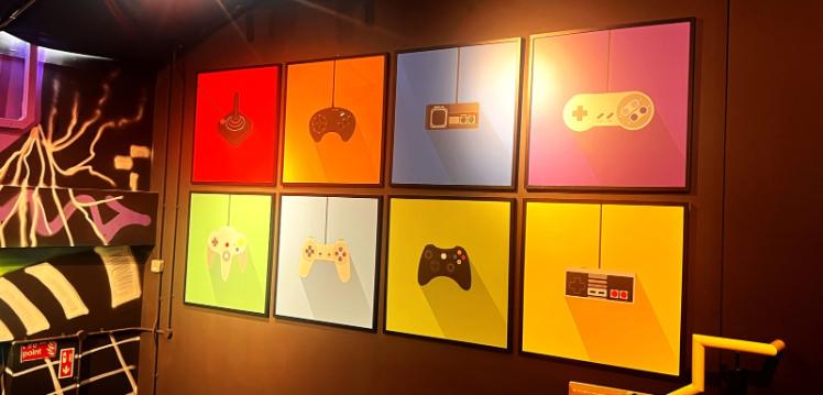 Wall art in Reboot cafe showing different types of gaming console remotes