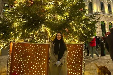 Student in front of Regent Street Christmas tree