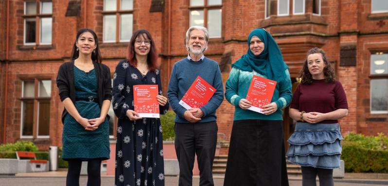 Group involved in the report launch outside Riddel Hall holding copies of the report