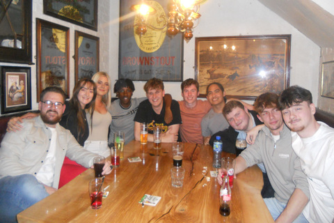 Student Sam with a group of friends sitting together at a table in a bar