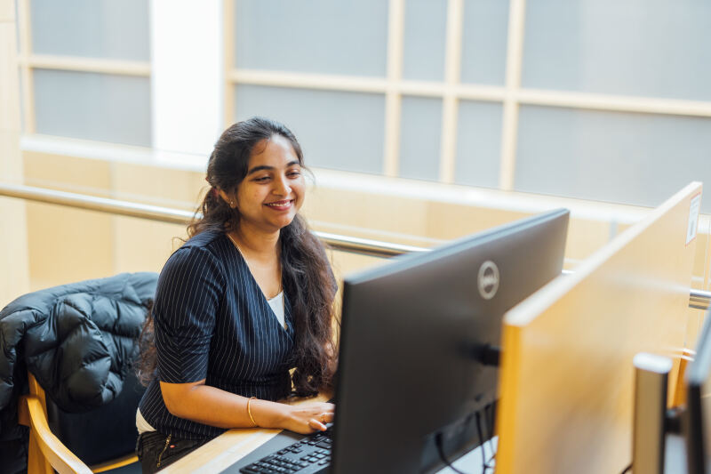 Student Sanjana studies at computer in the McClay Library
