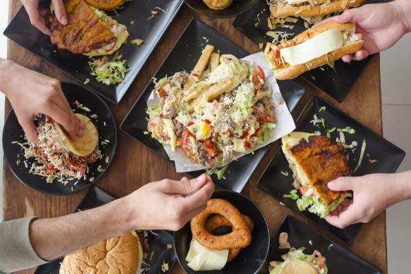 Group sharing small plates of food across a table