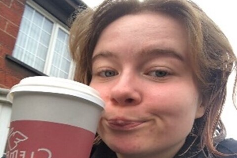 Student holding Clements coffee cup