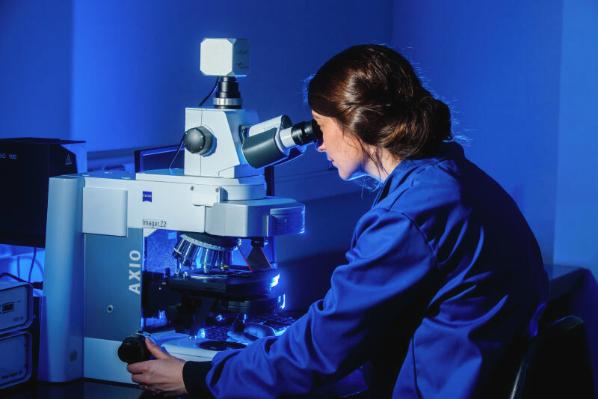 Student looking at sample under microscope