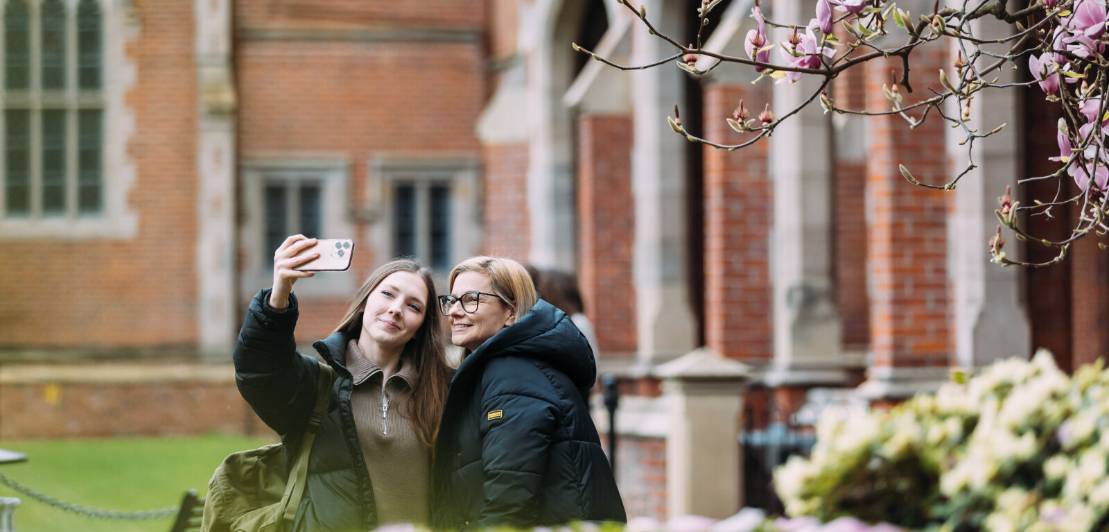 Female student and their parent taking a selfie on the quad
