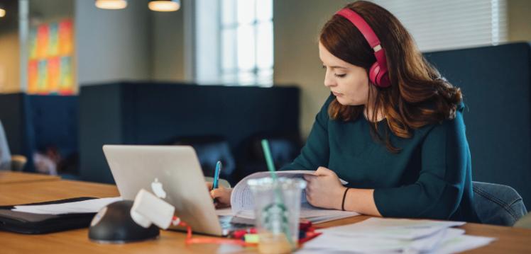 Student studying on laptop with headphones on