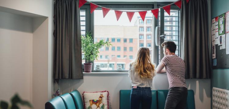 Two students looking out window in accommodation