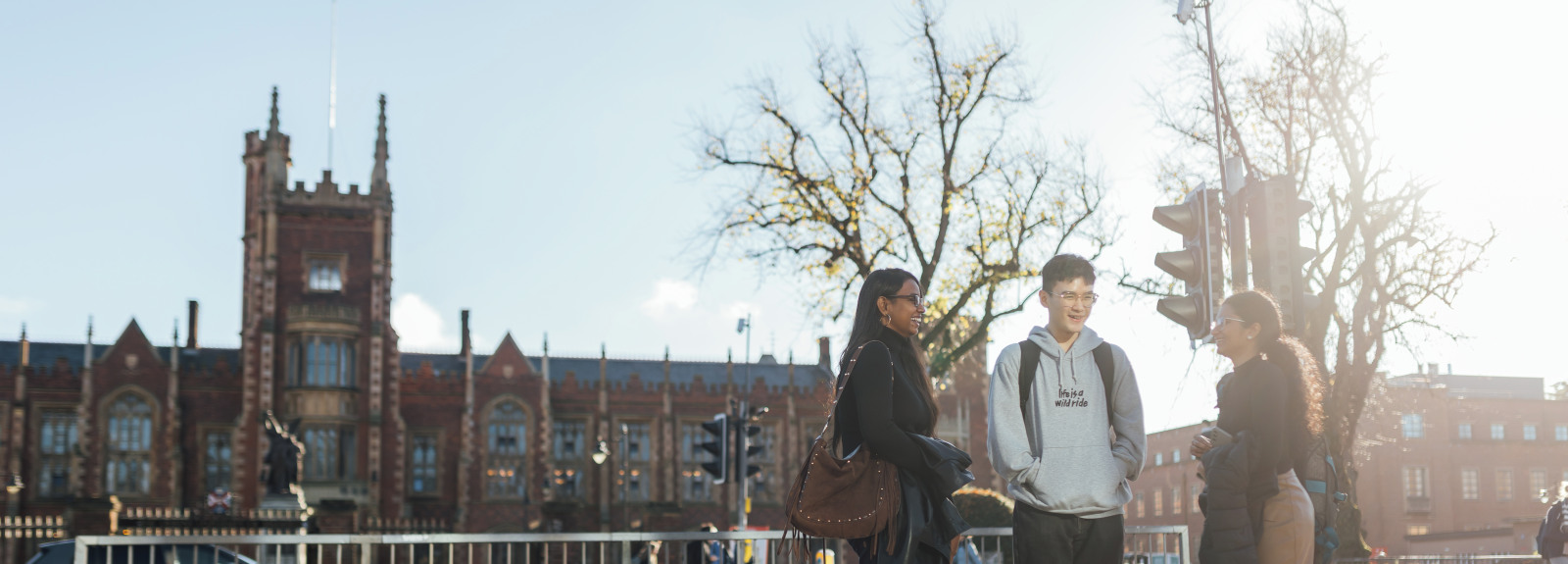 Three students standing across the street from the Lanyon building