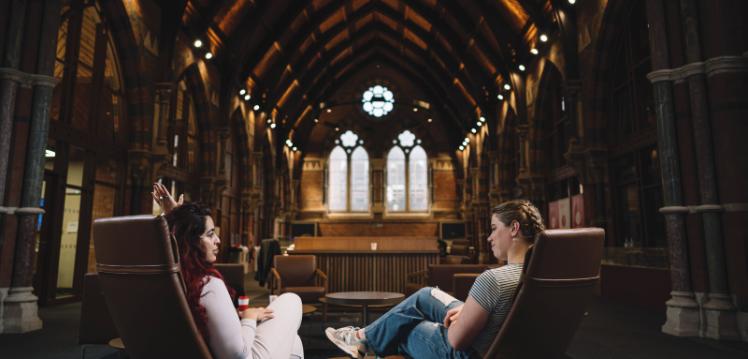 Two female students in the seating area of the Graduate School