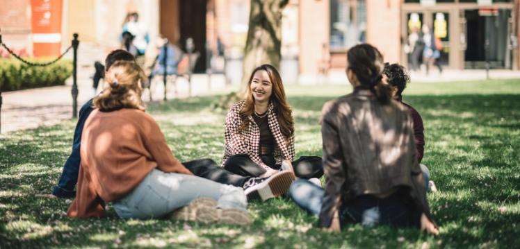 Group of students sitting on the grass in the quad