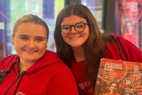 Two students working at Queen's University Autumn Fair