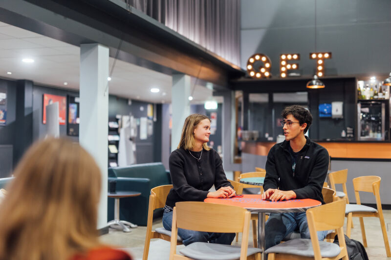 Students Tessa and Lucas sitting in QFT foyer