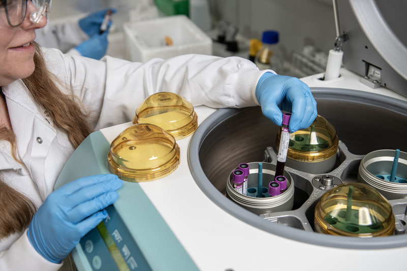 Lab technician looks at test tubes