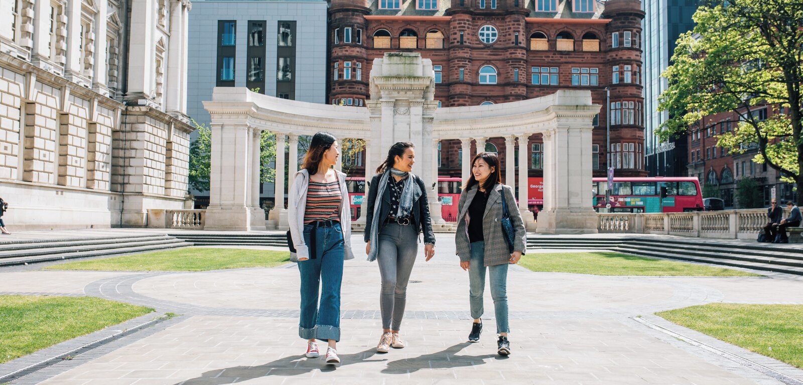 Three students walking at the side of Belfast City Hall