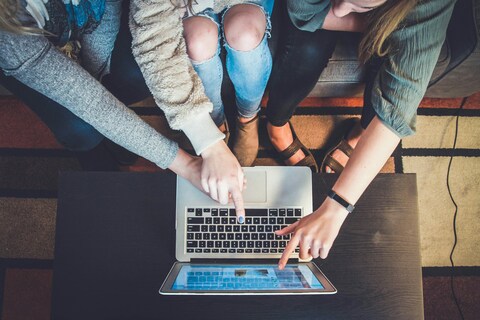Three people in front of laptop