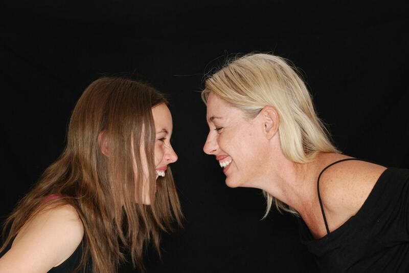 Young girl and woman laughing at each other