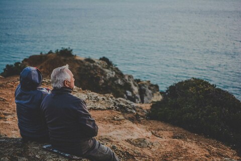 Two people sitting on a rock
