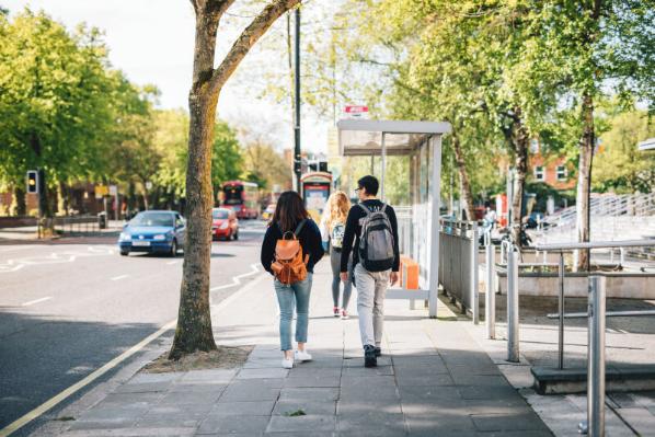 Two students walking down uni square