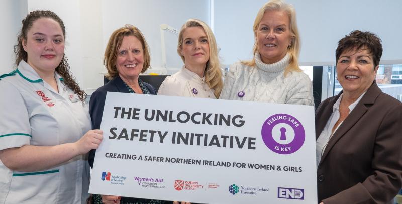 Women standing with a prop