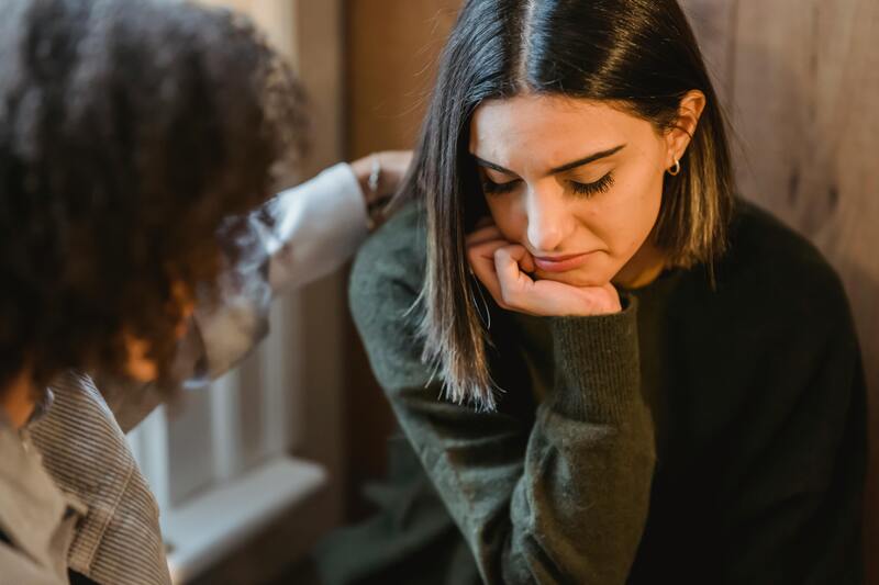 Upset woman being comforted by friend