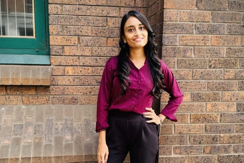 Student Veena Goudar standing in front of building
