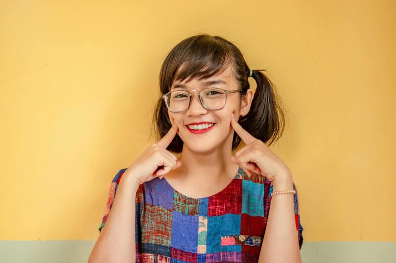 Woman smiling and touching her cheeks